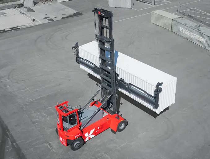 Portacontenedor eléctrico Kalmar ECG90-110 manipulando contenedor en centrro logístico.